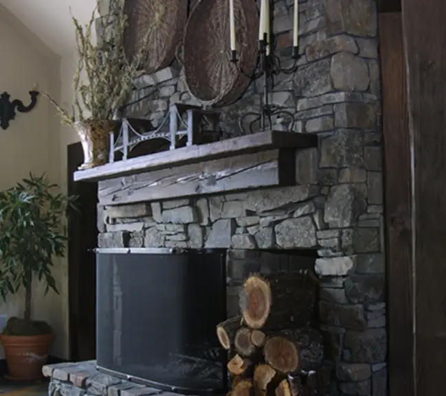 Rustic stone fireplace with wood mantel and decor